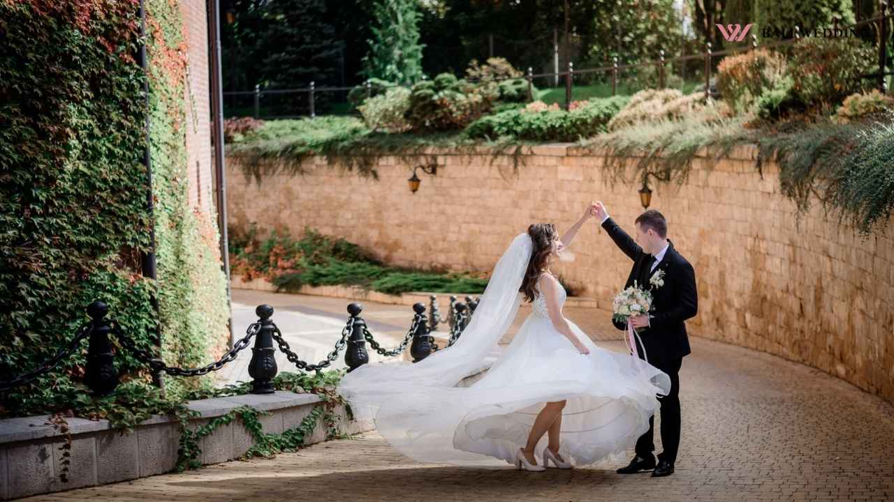 The bride and groom dancing outdoors, with the bride's dress flowing in the air.