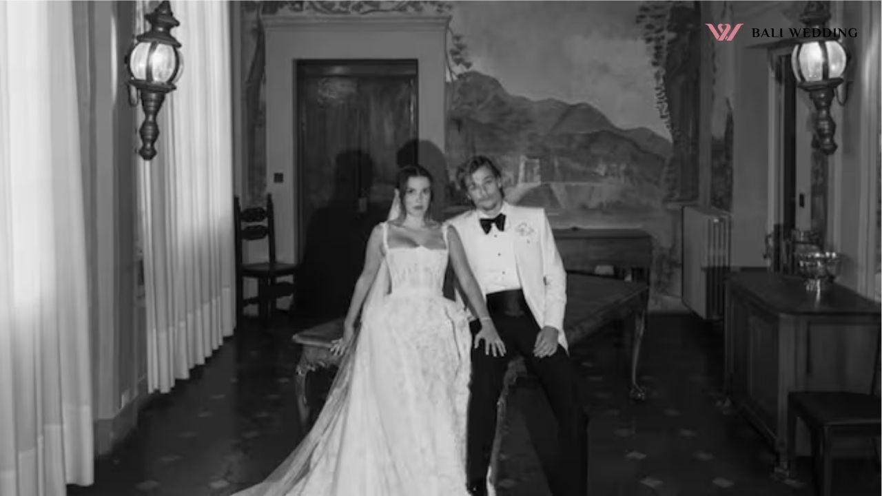 A black-and-white photo of the bride and groom sitting in an elegant, classic room with sophisticated decor.