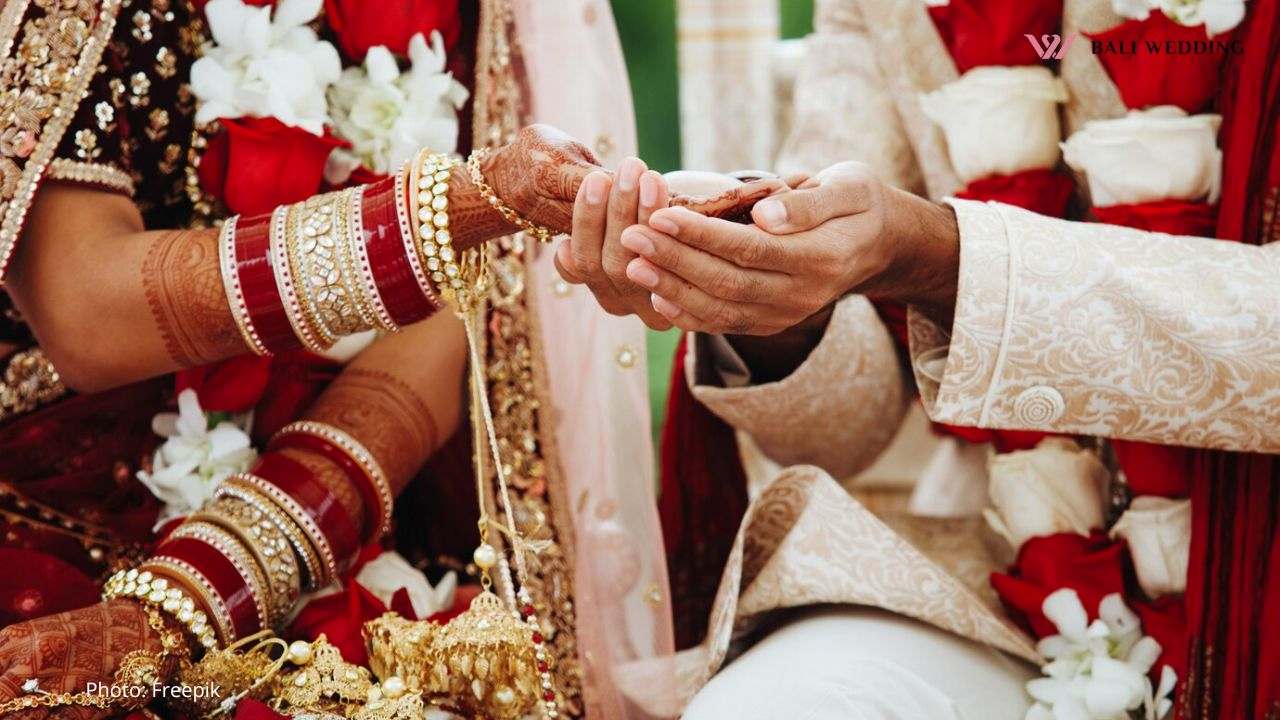 Hands of indian bride and groom intertwined together making authentic wedding ritual
