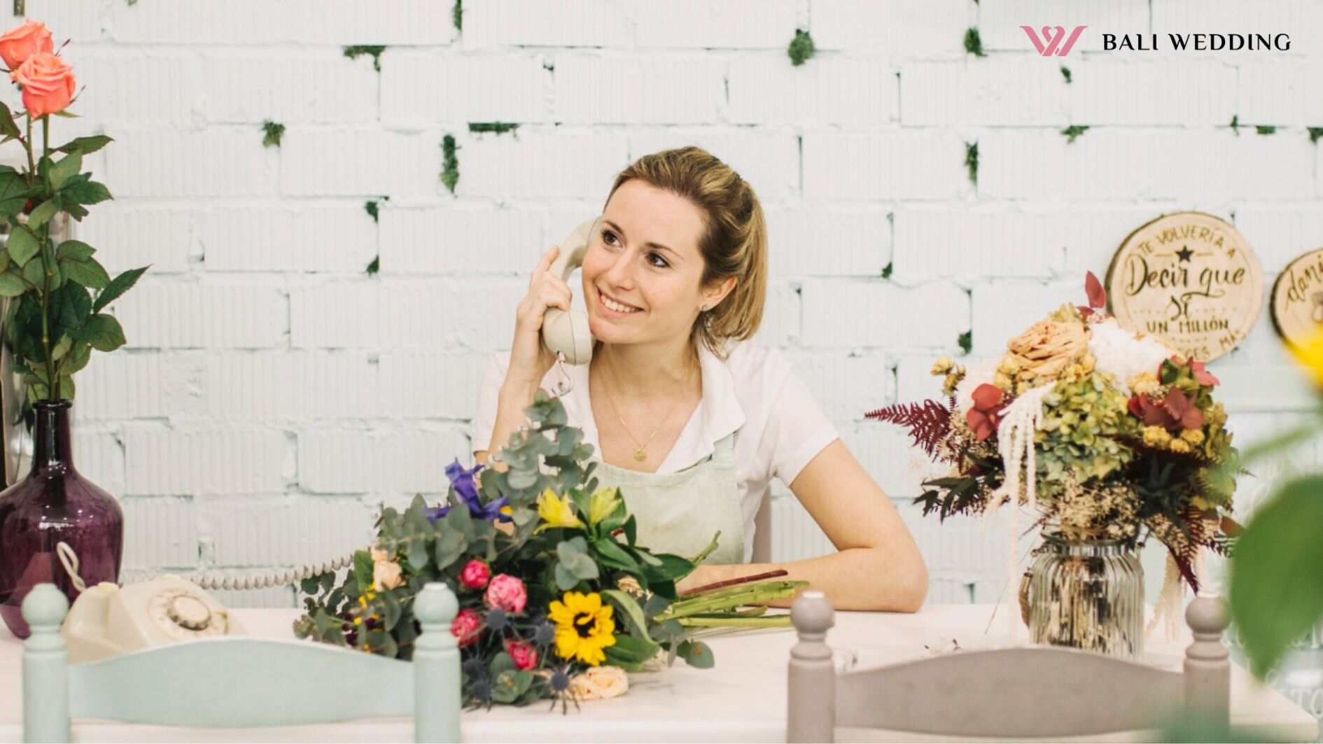 Charming florist talking on phone at table