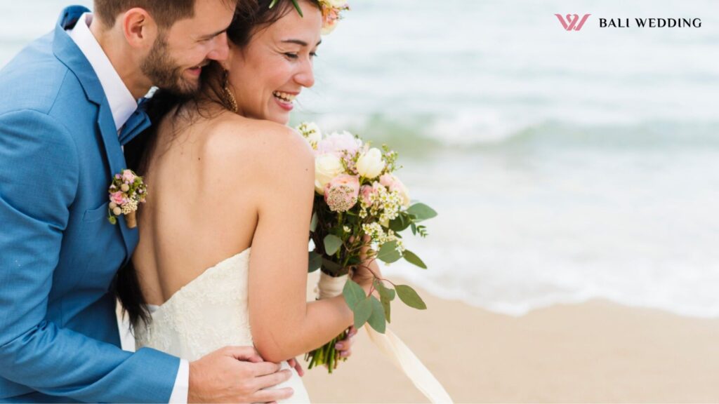 Cheerful newlyweds at beach wedding ceremnoy