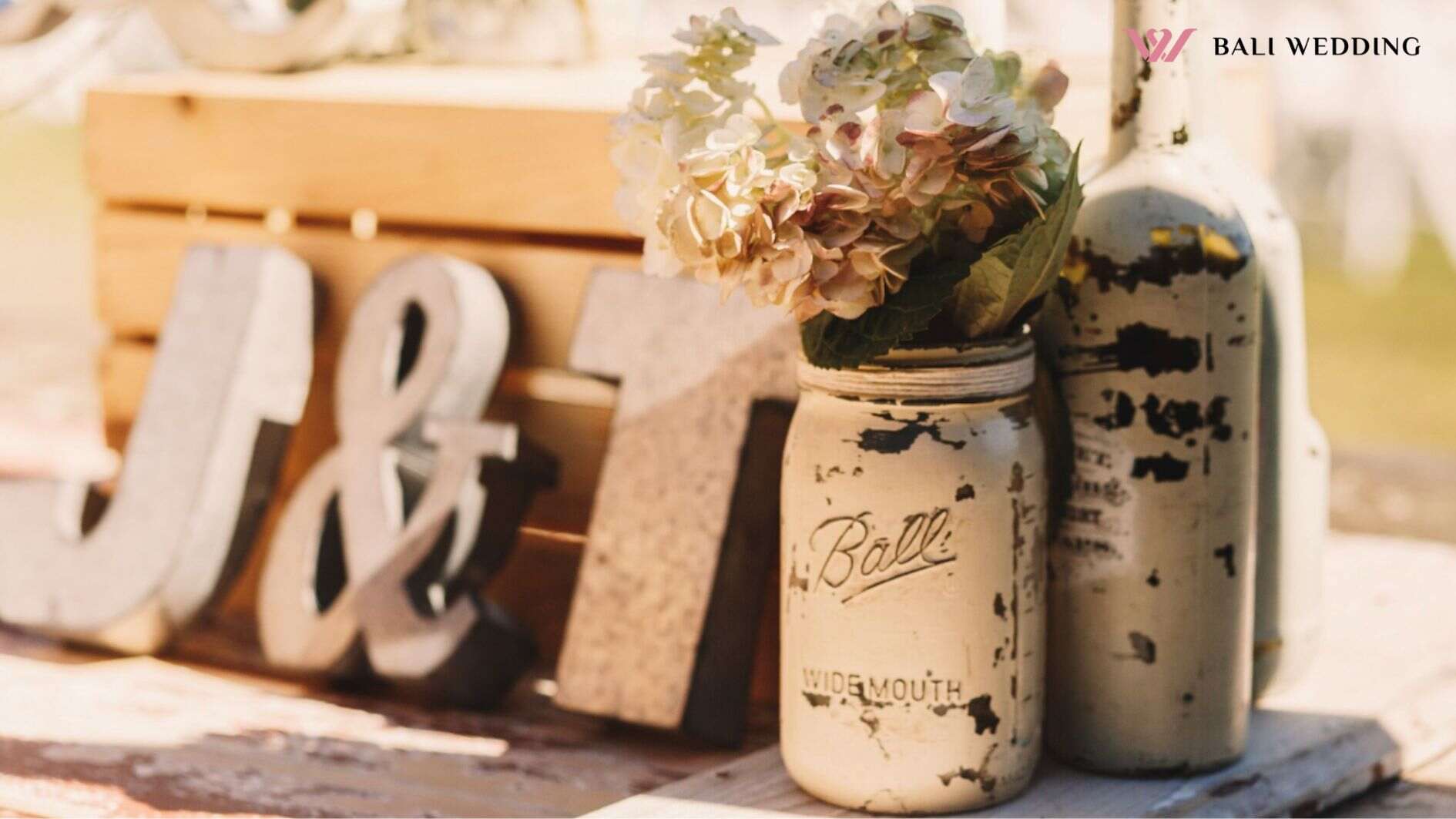 White old bottles with beige flowers stand before wooden