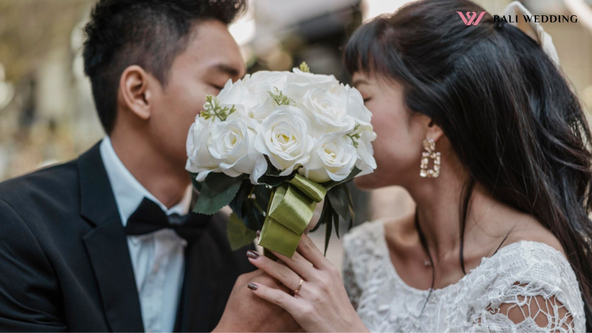 videografer Bali, Side view of bride and groom hiding faces behind bouquet of flowers